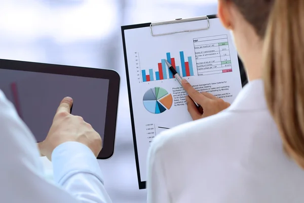 Geschäftskollegen, die an einer Grafik arbeiten und Finanzzahlen analysieren — Stockfoto