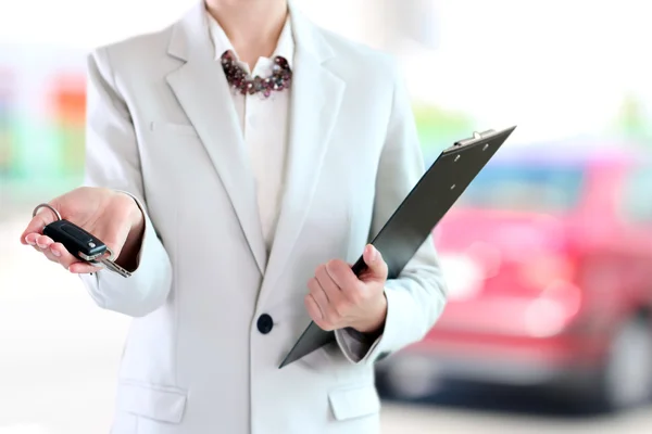 Young successful businesswoman offering a car key. — Stock Photo, Image