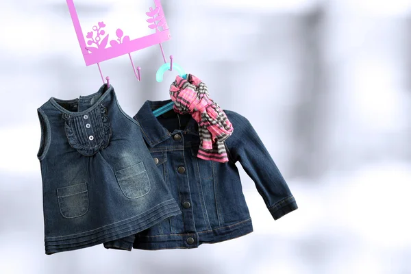 Fashion baby dresses hanging on a hanger on a green  background — Stock Photo, Image