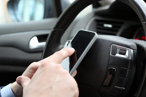 Podnikatel, pomocí mobilní chytrý telefon za jízdy auto — Stock fotografie