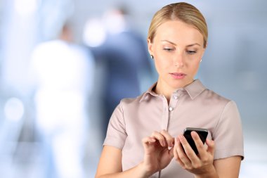 Holding ve mobil akıllı telefon kullanan iş kadını