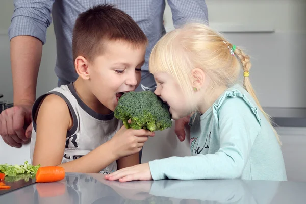 Ler söta dotter och son bita en broccoli. Lilla childre — Stockfoto