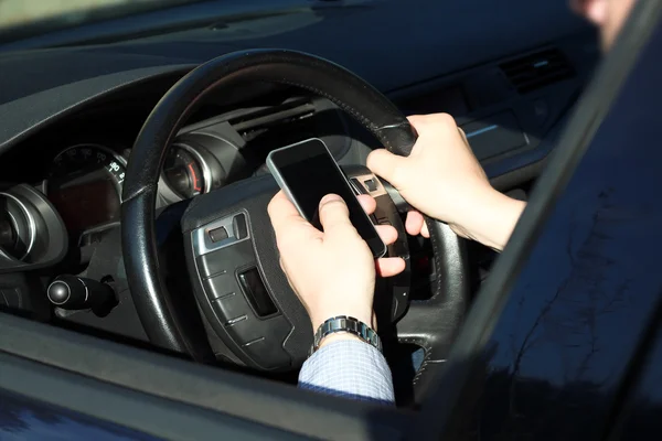 Podnikatel, pomocí mobilní chytrý telefon za jízdy auto — Stock fotografie