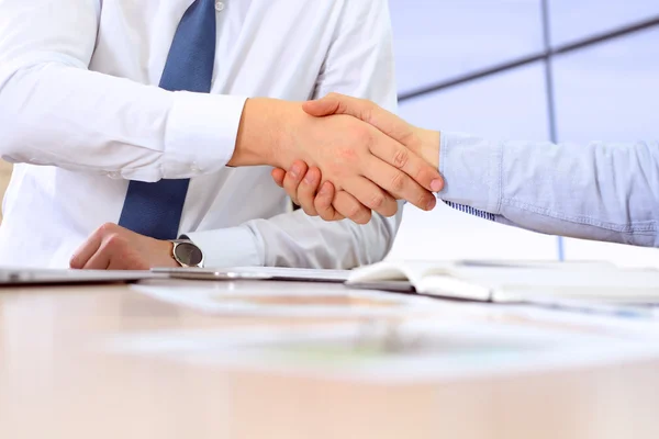 Close-up image of a firm handshake between two colleagues after signing a contract — Stock Photo, Image