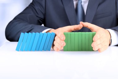 Planlama, risk ve strateji iş, ahşap bloklar tutan işadamı. İşadamı Domino etkisi durdurma
