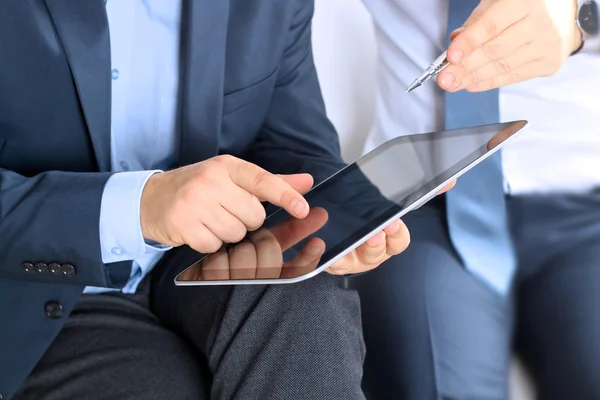 Collega's samenwerken en het analyseren van financiële cijfers op een digitale tablet — Stockfoto