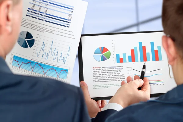 Affärskollegor arbetar tillsammans och analysera ekonomiska siffror på ett diagram — Stockfoto