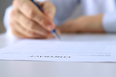 İş adamı kontrat imzalıyor, iş sözleşmesi detayları.