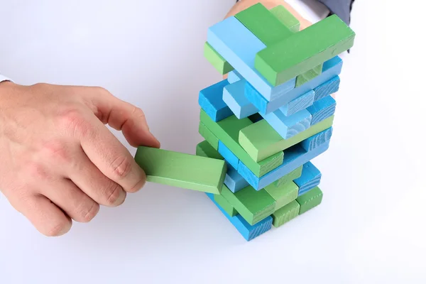 Planning, risk and strategy in business, businessman getting out a wooden block from a tower — Stock Photo, Image