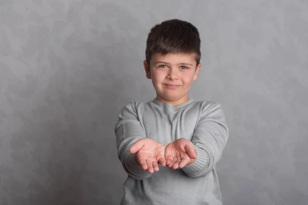 바탕에 아이의 모습이 손가락으로 즐겁고 몸짓을 보인다 소년의 상징적 동작을 — 스톡 사진