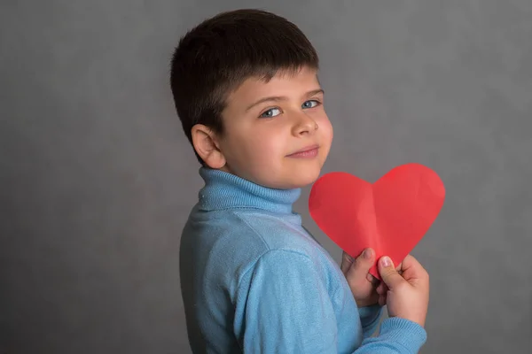 소년은 종이에서 잘려나간 심장을 아이는 심장의 형태로 종이에서 발렌타인 카드를 — 스톡 사진