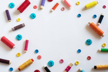 Çerçeve. Beyaz arka planda farklı renk ve boyutlarda iplikleri olan makaralar. Düz yatıyordu. Metin için yer