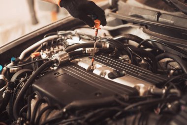 Oto tamircisi araba tamir eder. Çalışan makinenin bakımını yapar..