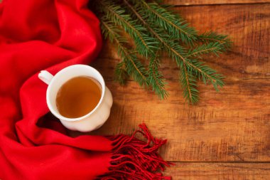 Kış, sıcak atmosfer. Kırmızı eşarplı ve ahşap kaplamalı bir fincan sıcak siyah çay. Kış akşamı. Düz konum, yerleşim, metin, kartpostal, yüksek çözünürlük