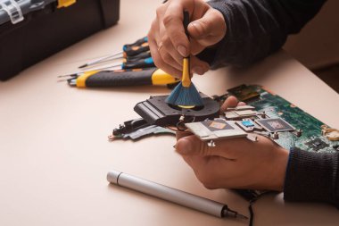 Sihirbaz dizüstü bilgisayarı restore eder. Dizüstü bilgisayarın yedek parçalarına ayrılması. Tahta, iyileşme için dizüstü bilgisayarın bir parçası. Aletleri kullanarak bilgisayar ekipmanlarının bakımı. İçerideki dizüstü bilgisayara bak