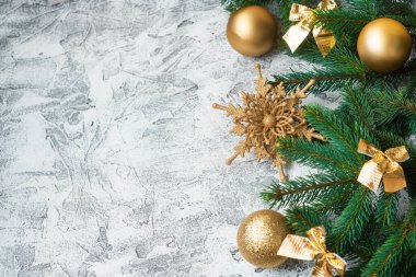 Yeni yıl ya da noel kompozisyonu ladin yeşil dalları ve yeni yıl, parlak dokularda parlak altın oyuncaklar ve yıldızlar. Düz yatış, düzen, çerçeve, metin için yer, kopyalama alanı, üst görünüm