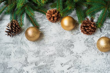 Yeni yıl ya da Noel kompozisyonu ladin yeşil dalları, çam kozalakları ve yeni yıl, parlak bir doku arka planında parlak altın ve oyuncaklar. Düz döşeme, düzen, çerçeve, metin için yer, kopyalama alanı