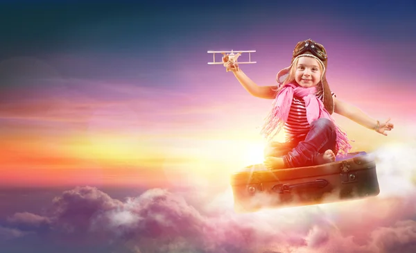 Enfant volant avec fantaisie sur une valise dans le ciel — Photo