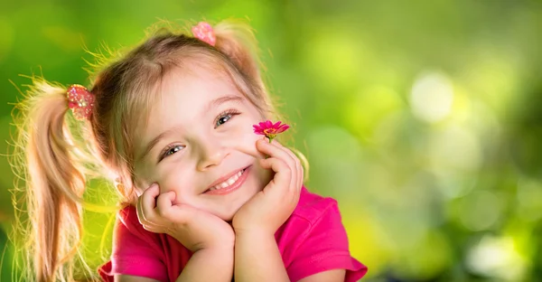 Liten flicka tänkande med Daisy i språng grön — Stockfoto