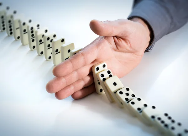 Dominoeffekt stoppen - Hand verhindert Fehlschlag — Stockfoto