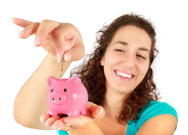 Woman inserting coin into piggy bank — Stock Photo, Image