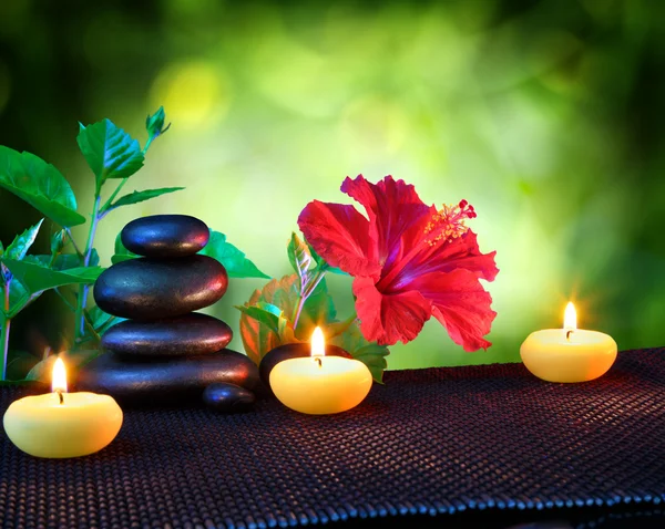 Kerzen und Steine Wellness-Komposition - mit Hibiskus — Stockfoto