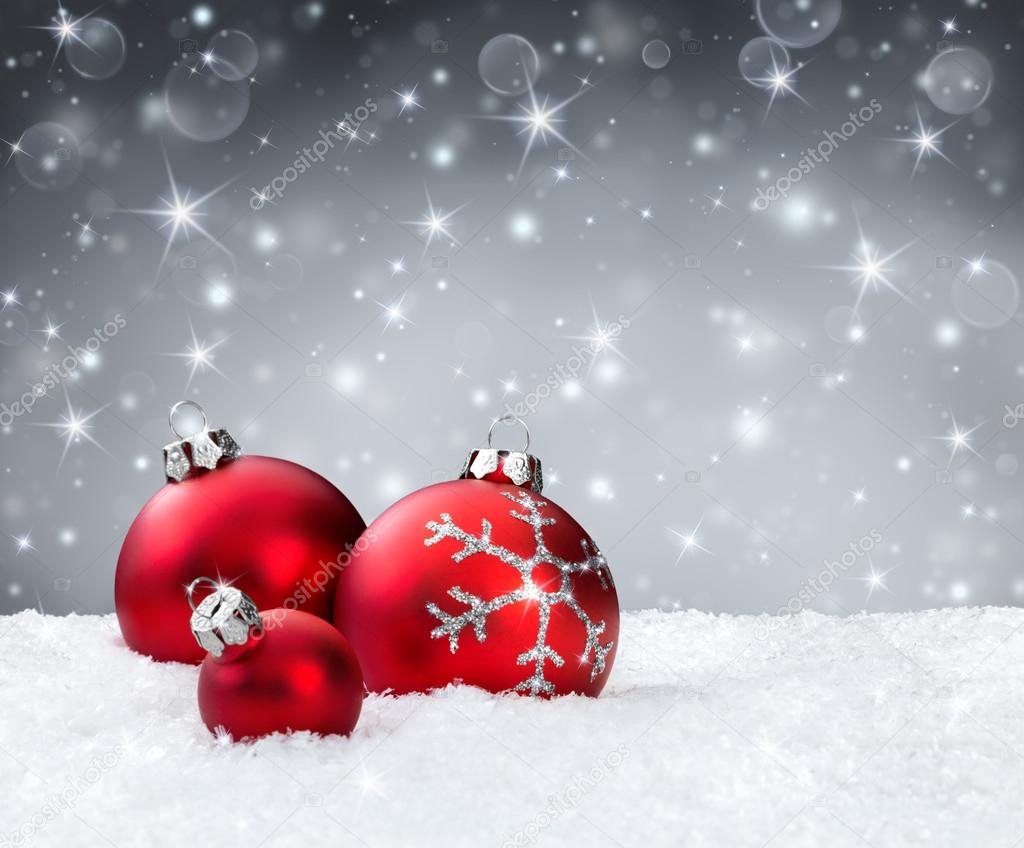 Red baubles on snow with silver sparkle background