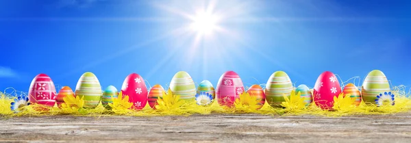 Яйця Великодня в ряд на соломі - великодній прапор — стокове фото