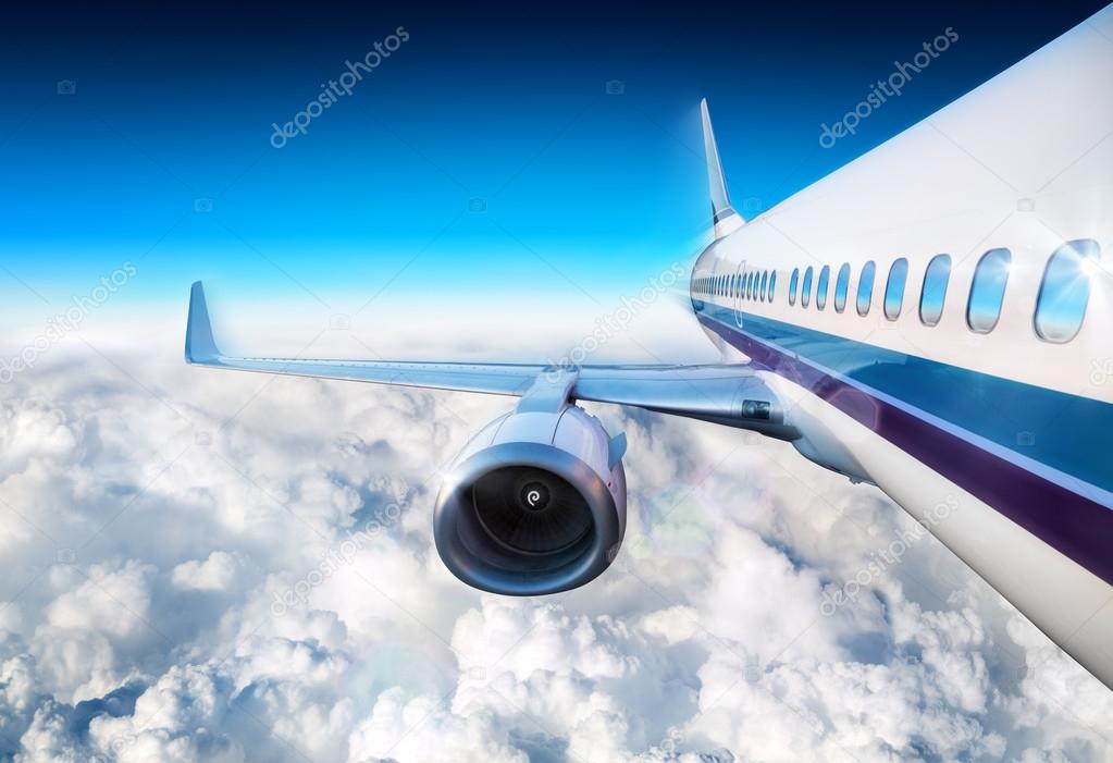 Airplane over clouds flying in blue sky