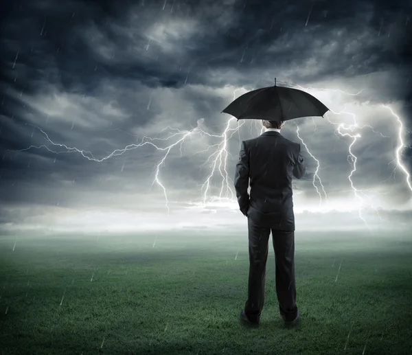 Ryzyka i kryzys - biznesmen poniżej burza z parasolem — Zdjęcie stockowe