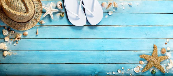 Muscheln auf blauem Holzplank mit Strohhut und Flip-Flop — Stockfoto