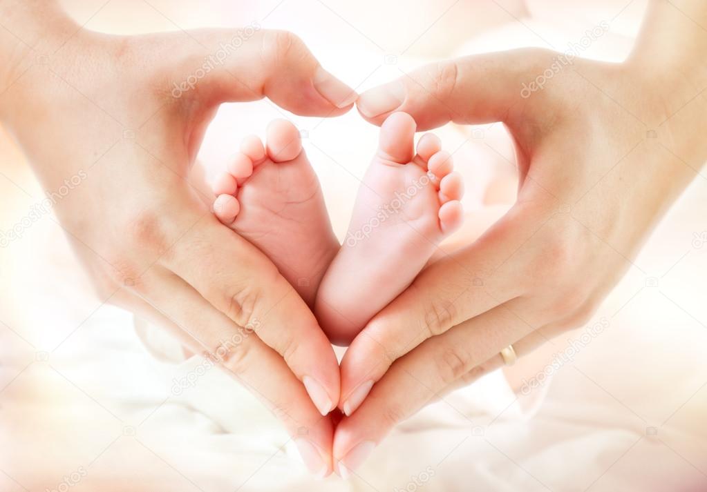 baby feet in mother hands - hearth shape