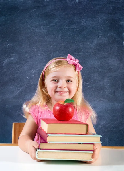 可爱的女生，拿着书和苹果与黑板背景 — 图库照片