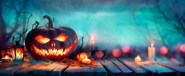 Cadılar Bayramı Balkabakları Alacakaranlıkta Masada - Odaklanmamış Ormandaki Jack O Lantern