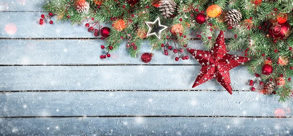 Árbol de abeto y estrella en fondo de madera con copos de nieve y luces —  Fotos de Stock