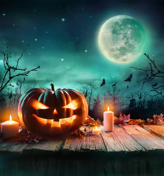 Halloween-Kürbis auf Holzplanke mit Kerzen in einer gruseligen Nacht — Stockfoto