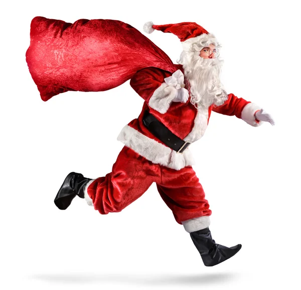 Santa Claus corriendo con una bolsa de regalos sobre un fondo blanco — Foto de Stock