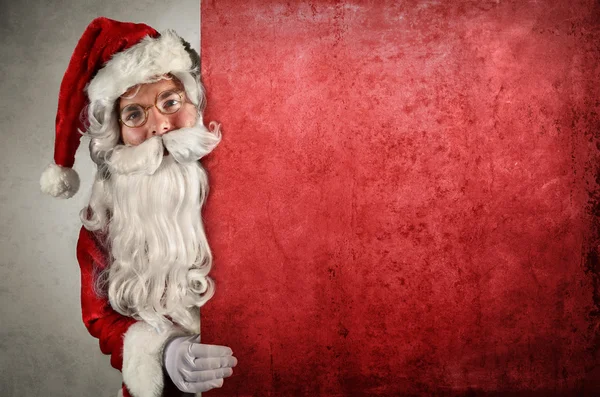 Santa Claus mostrando detrás de la cartelera — Foto de Stock