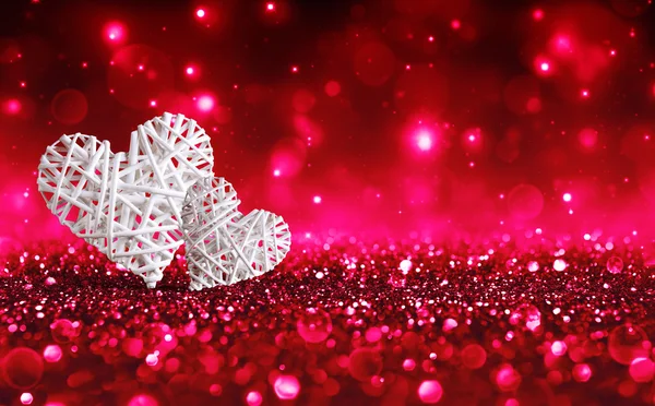 Två flätade hjärtan på Red Sparkle Glitter — Stockfoto