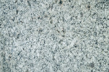 Gri granit taşın pürüzsüz yüzeyi, taşın sanatsal yapısı gölgede doğal gün ışığı altında fotoğraflanır..