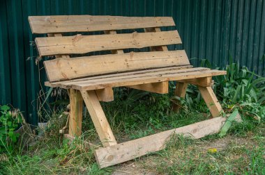 Planlanmamış ahşap kalaslardan yapılmış orijinal bir bank. Animasyon sanatına iyi bir örnek. Gündüz fotoğraflanmış..