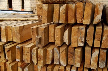 İnşaat alanındaki kaba ahşap kalaslar, kullanıma hazır, gündüz vakti yatay olarak fotoğraflanmış..