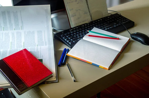 Bir öğrencinin iş yeri, kitaplar ve notlar bilgisayarla bir araya getirildiğinde bilgi edinmek için ideal bir kombinasyon oluşturur, gün ışığında bir ev odasında fotoğraf çekilir..