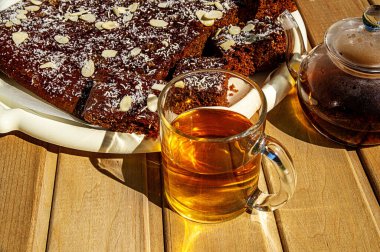 Yiyecek, beyaz çay tepsisinde tatlı zencefilli ekmek, güneş ışığında fotoğraflanmış..