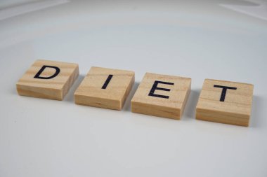 Tahta bir blokta beyaz bir tabakta diyet sözcükleri