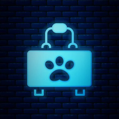 Parlayan neon evcil hayvan ilk yardım seti simgesi tuğla duvar arka planında izole edildi. Köpek ya da kedi pençesi izi. Klinik kutusu. Vektör.