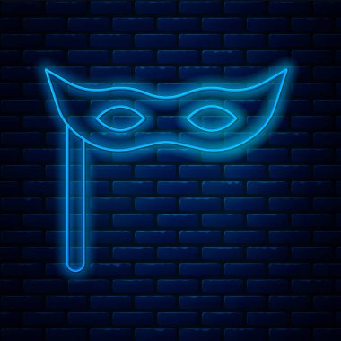 Parlayan neon çizgisi şenlik maskesi simgesi tuğla duvar arka planında izole edildi. Mutlu Noeller ve mutlu yıllar. Vektör.