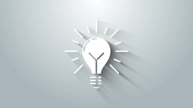 Işınlar parlayan beyaz ampul ve gri arka planda izole fikir ikonu konsepti. Enerji ve fikir sembolü. İlham konsepti. 4K Video hareketli grafik canlandırması