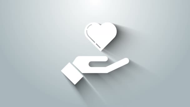 Corazón blanco en la mano icono aislado sobre fondo gris. Mano dando símbolo de amor. Animación gráfica de vídeo 4K — Vídeos de Stock