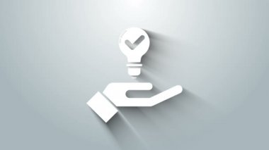 Gri arkaplanda el simgesinde beyaz ampul var. Fikir kavramı. 4K Video hareketli grafik canlandırması